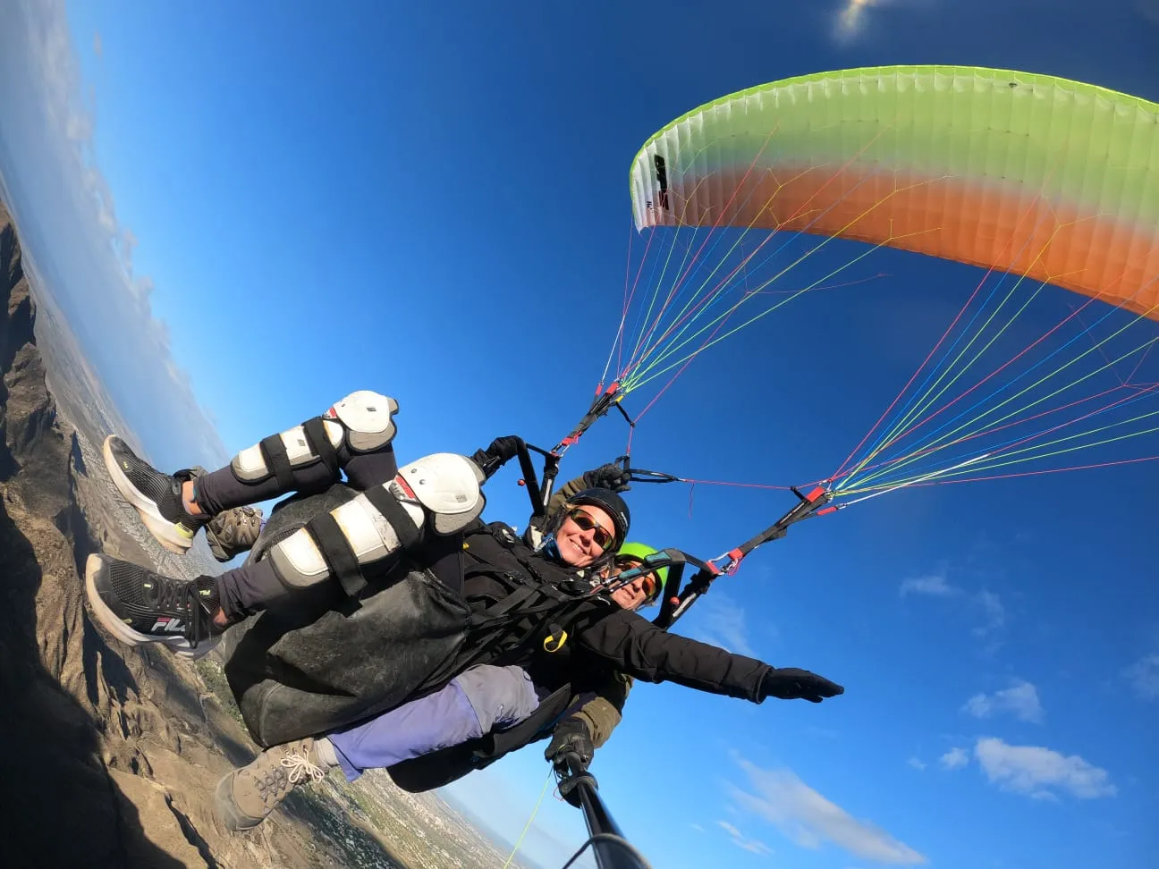 Dos personas volando en parapente tándem sobre las montañas de Mendoza